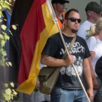 Mann mit großer Deutschlandflagge.